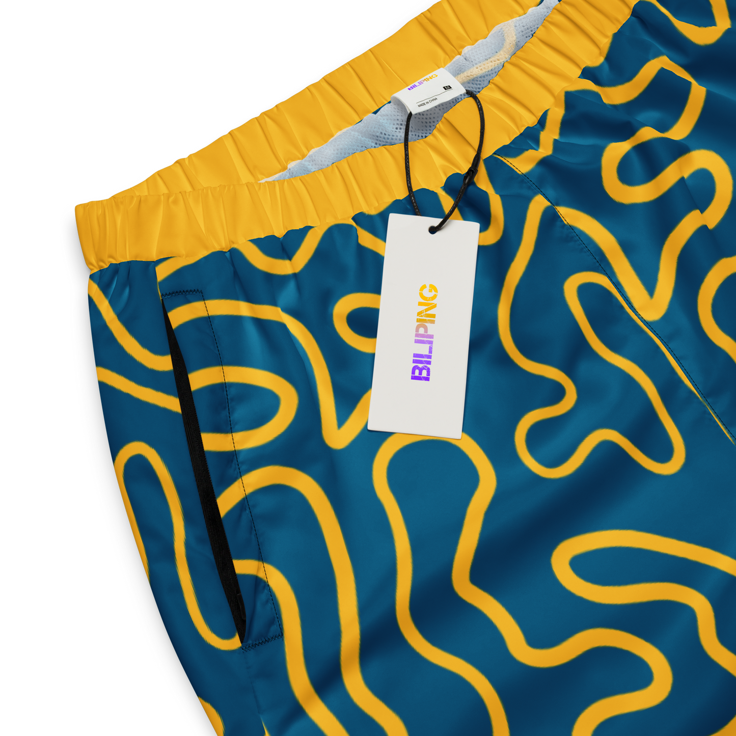 Wavy Line Track Pants with zipper and tag, showcasing elastic ankle cuffs.