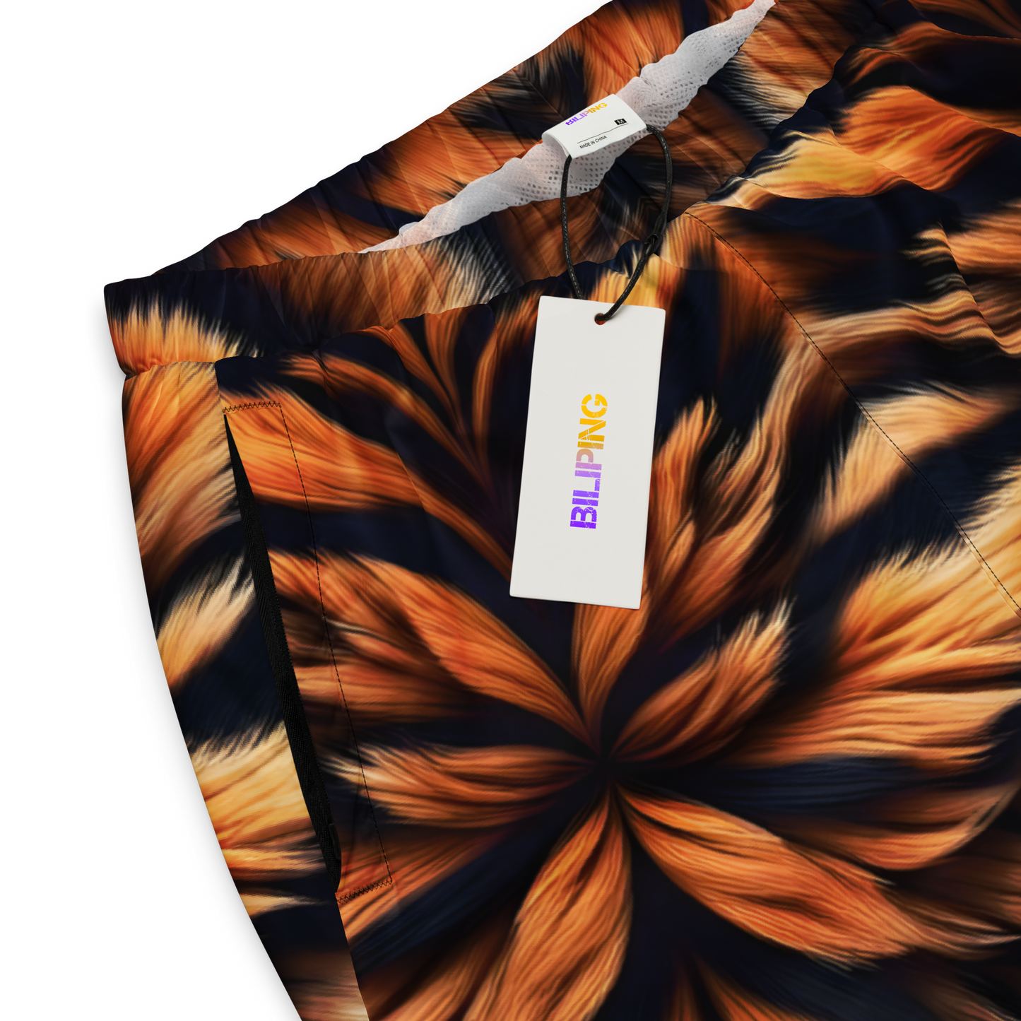 Ember Tiger Track Pants with tag, shown in close-up.