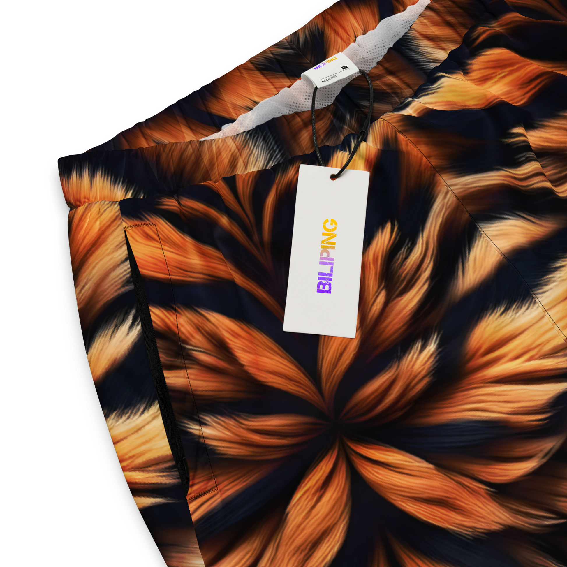 Ember Tiger Track Pants with tag, shown in close-up.