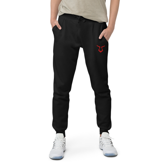V - Sweatpants close-up, featuring red bull logo on black fabric.